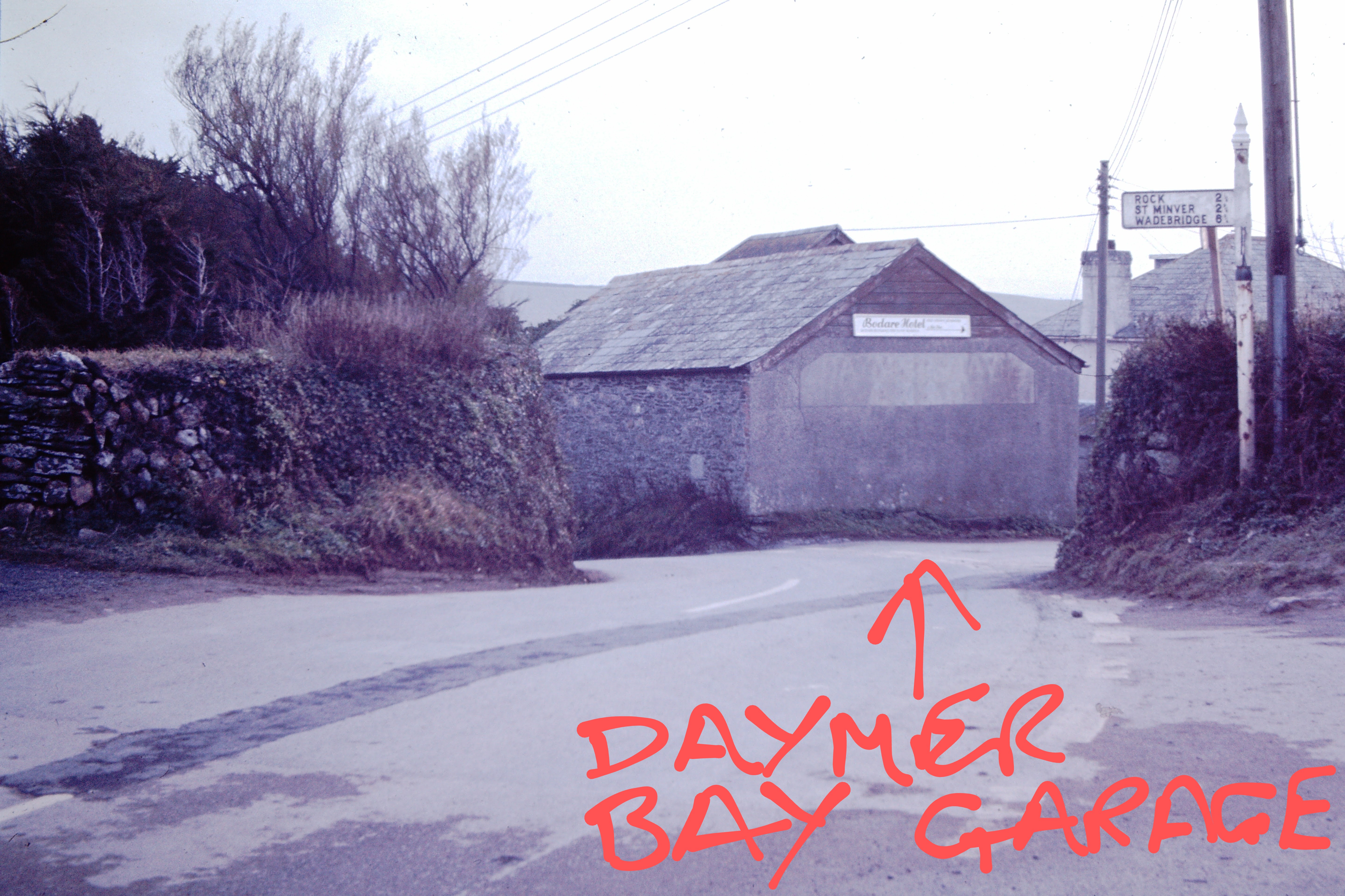 View of the junction between Daymer Lane and Worthy Hill  The gable end of the set of 4 garages~2